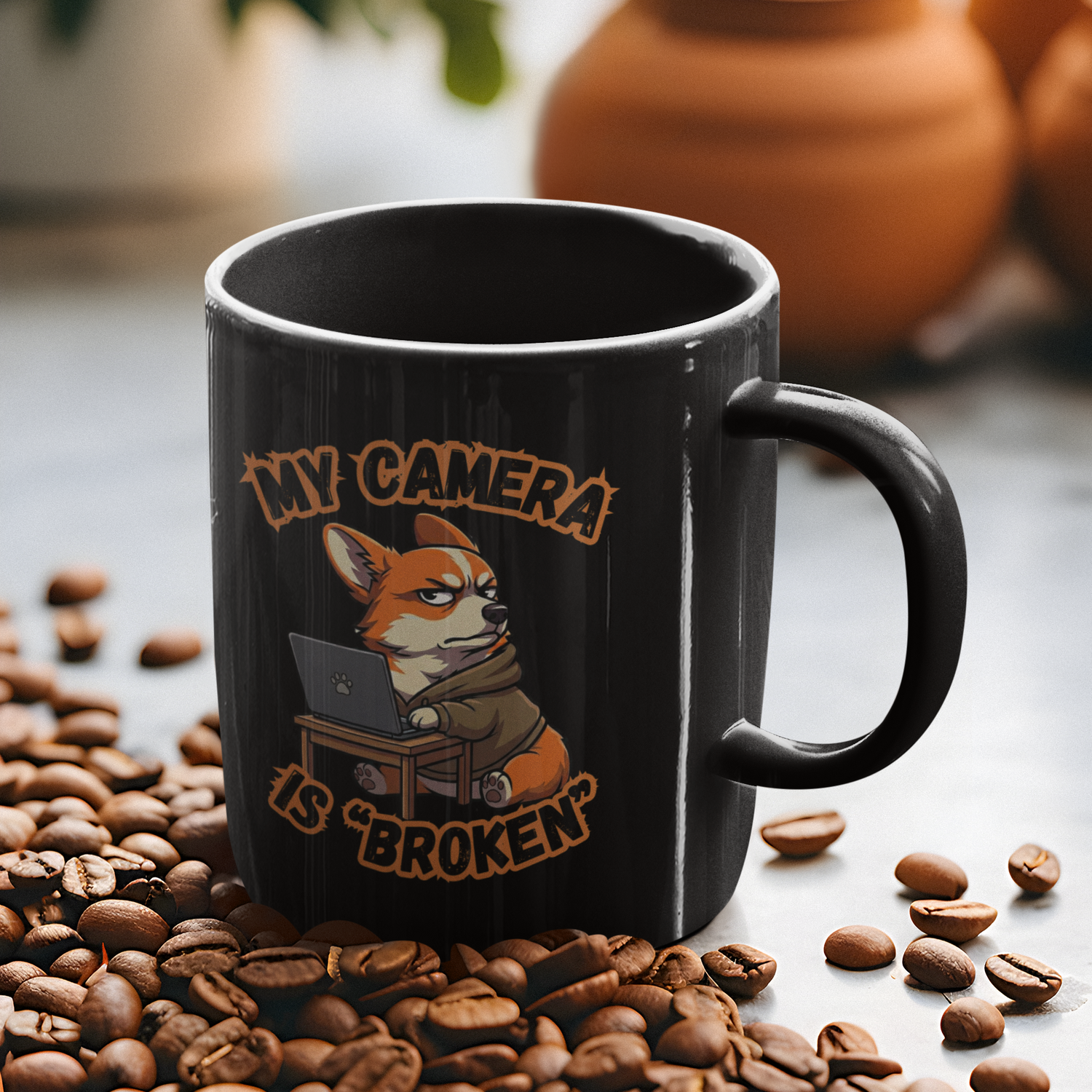 Black mug with a fox graphic and text 'My camera is broken' on coffee beans.