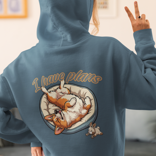 Person wearing a blue hoodie with a dog graphic and 'I have plans' text on the back, in a living room setting.