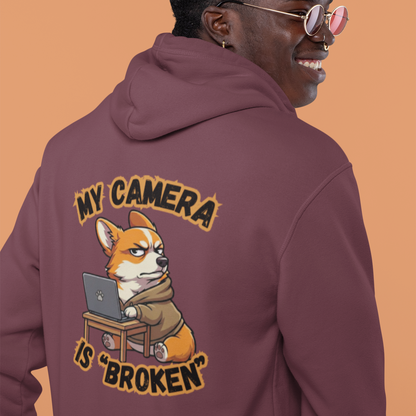 Person wearing a maroon hoodie with a graphic design on the back against an orange background